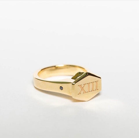 A custom engraved El Rey Signet ring in 14k yellow gold with black accent diamonds on the shank.