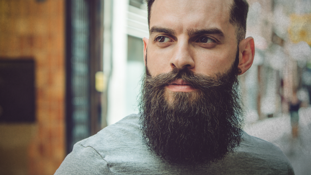 Man with thick beard looking at his side
