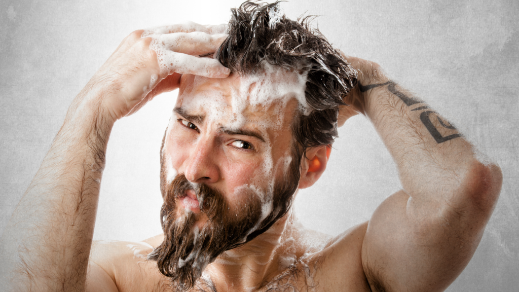 Man in shower washing his hair with shampoo