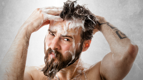 Man with beard in shower washing his hair