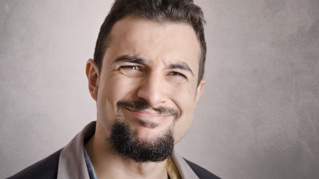 Man with goatee smiling in amusement