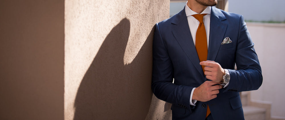 Man in suit fixing his watch