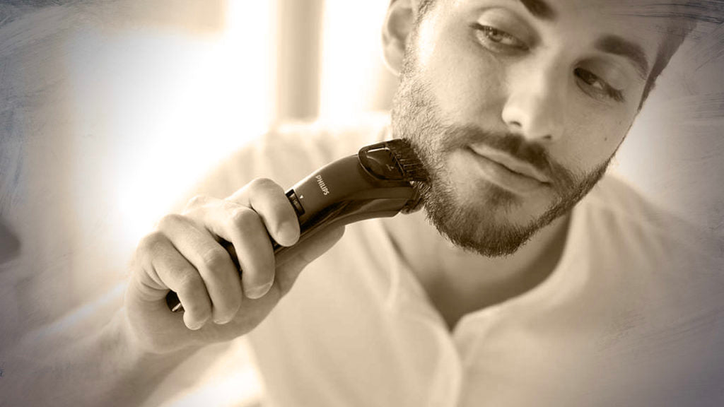 man with stubble trimming his beard