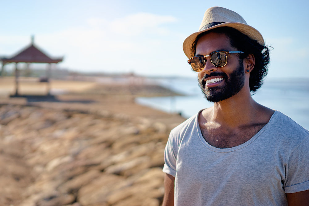 bearded man smiling by the beach