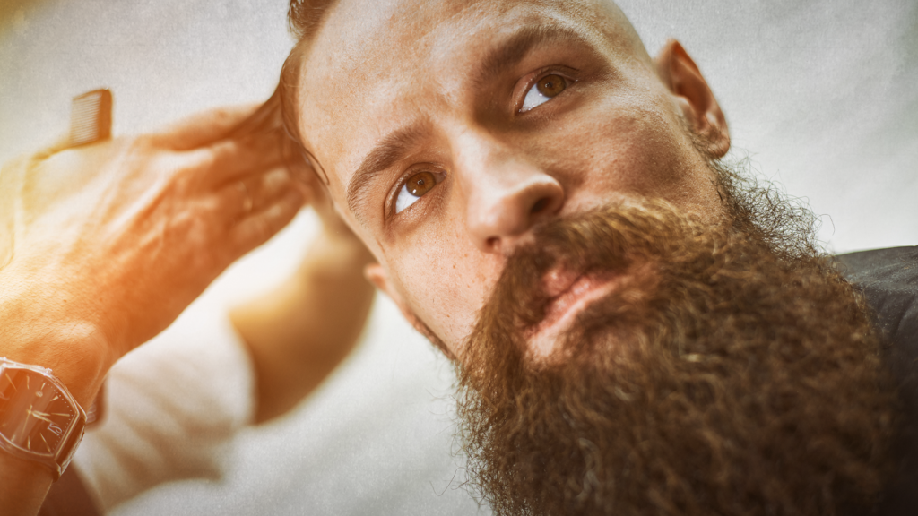 Man with long beard getting a trim in a salon