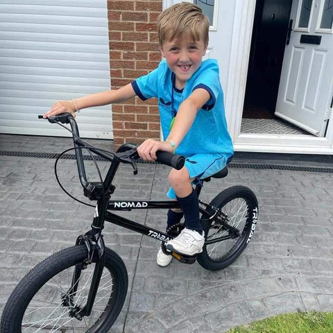 Kid at Christmas With New Tribal BMX Bike Smiling