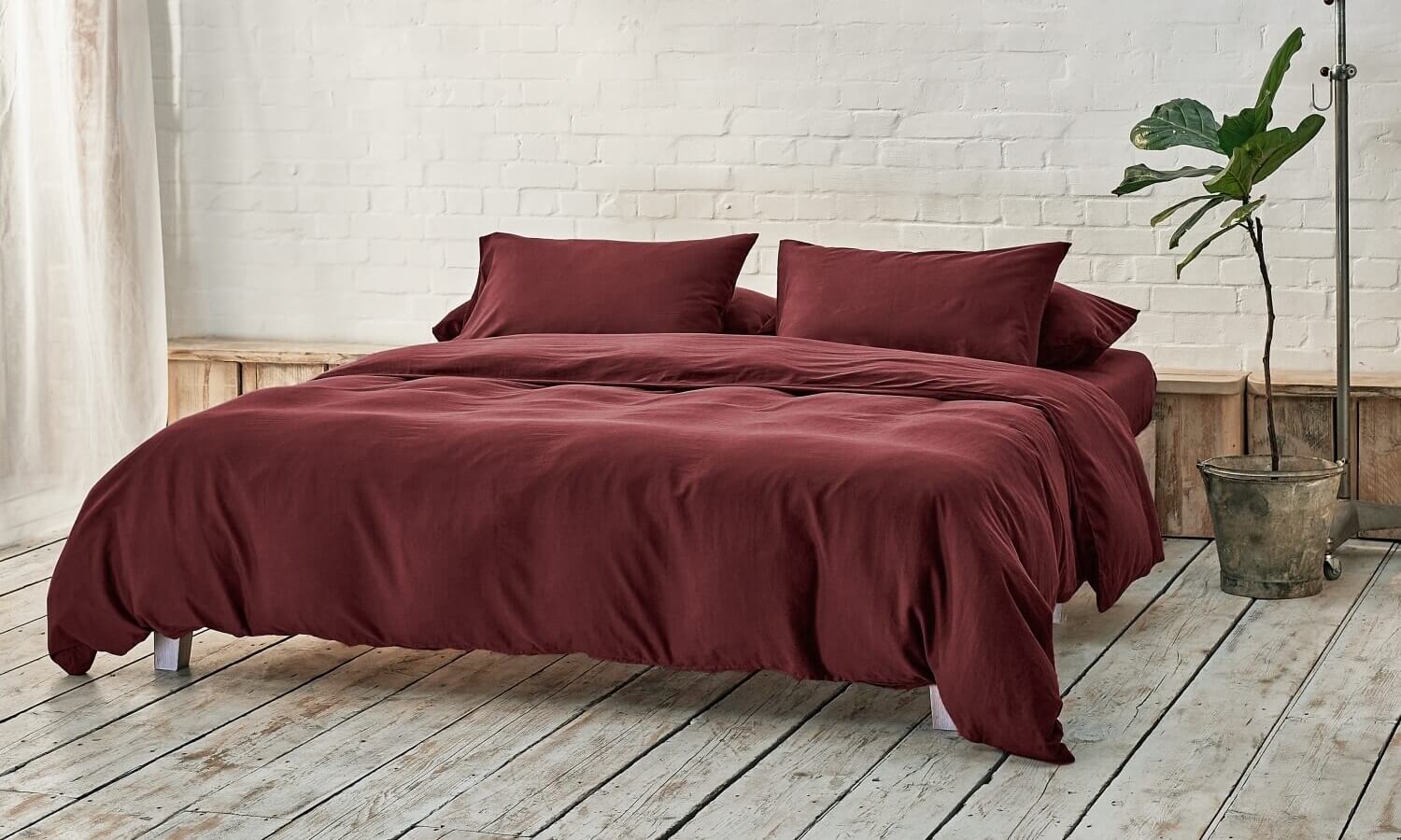 burgundy bedding on bed in a modern room