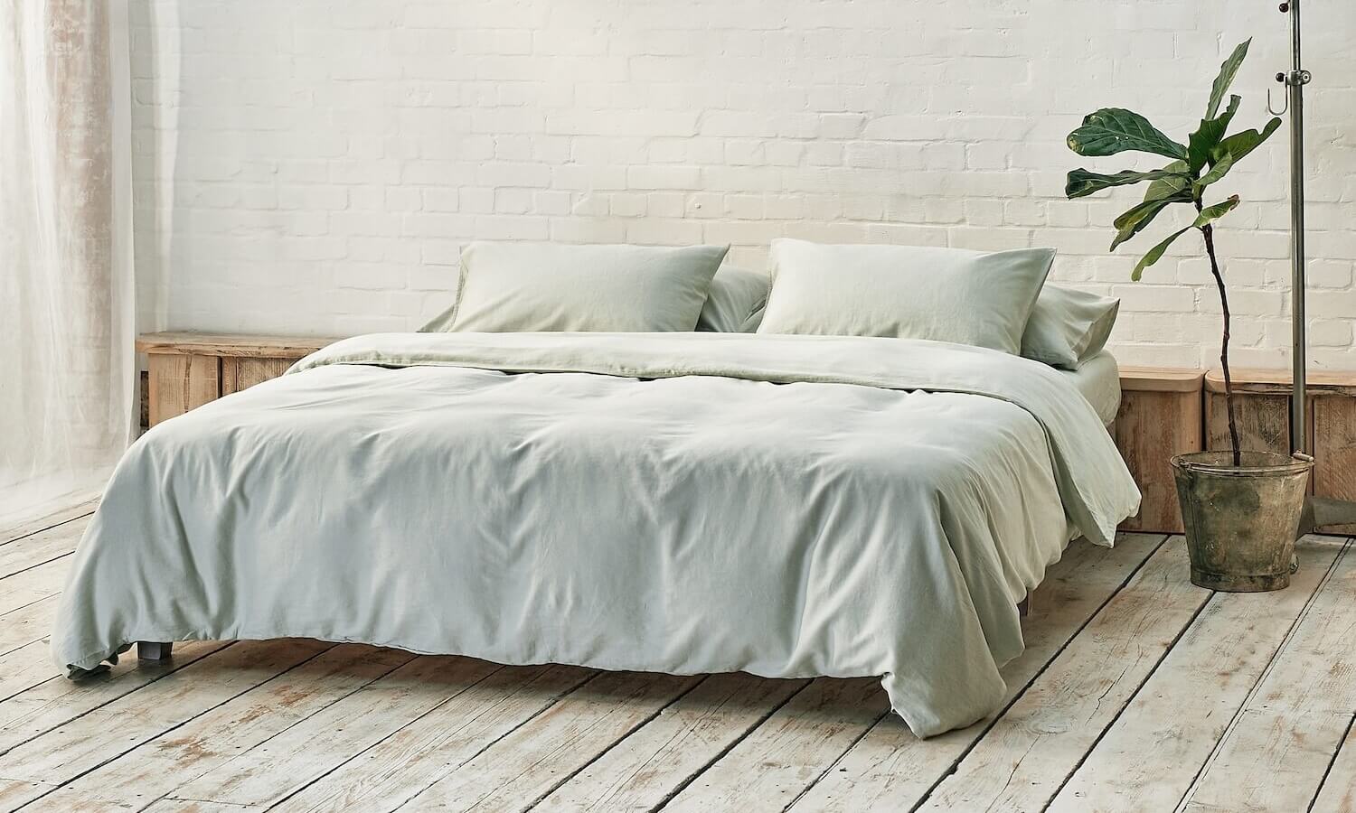 light sage green bedding on bed in a modern room