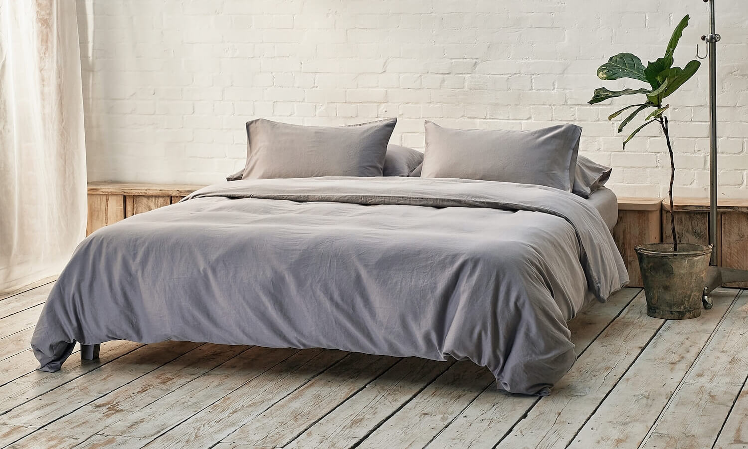 silver grey bedding on bed in a modern room