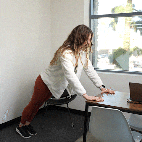 Woman demonstrating desk push-up exercise