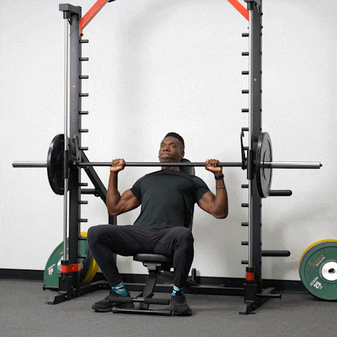 man demonstrating seated overhead press exercise