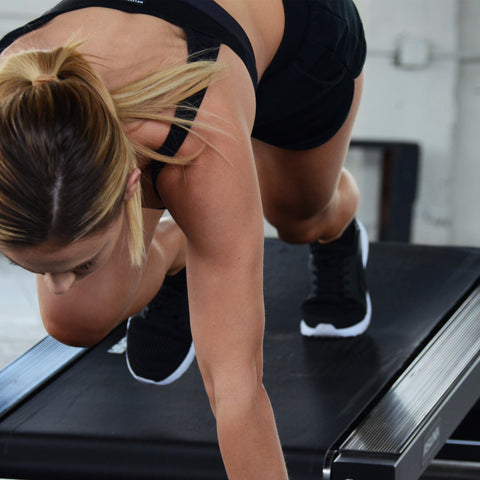 woman performing mountain climbers on treadmill