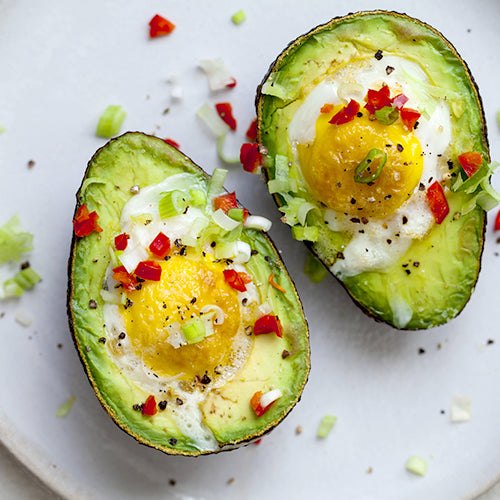 two avocados with eggs on the top