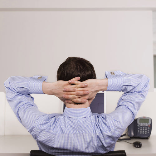 an office man is putting his hands on head and sitting