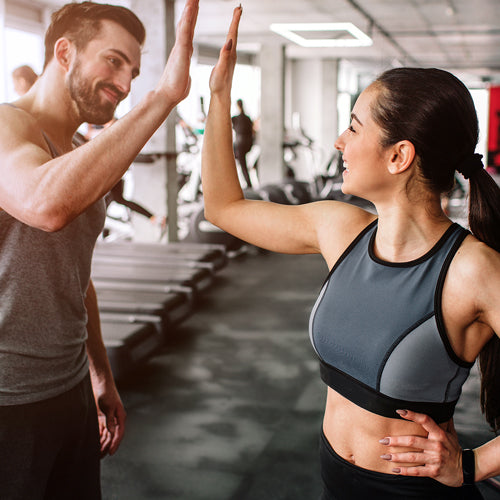 man and woman doing a high-five in gym