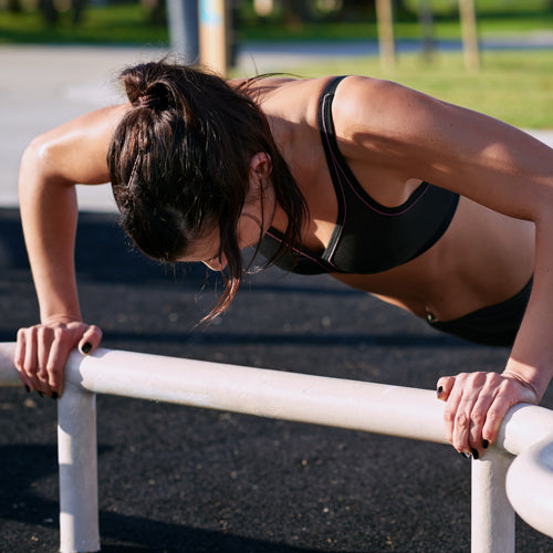 a female athlete is pushing up outdoors