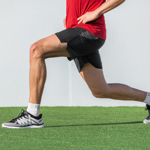 a man is doing forward lunge on grass