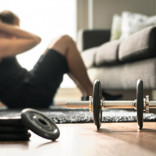 a man is sitting up with dumbbells in living room
