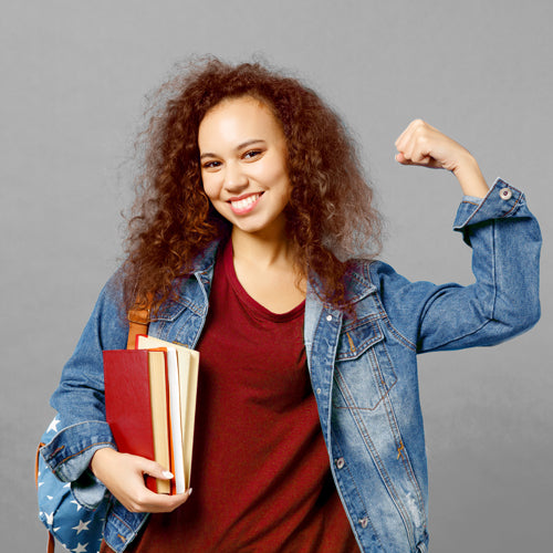 a student holding books and smiling
