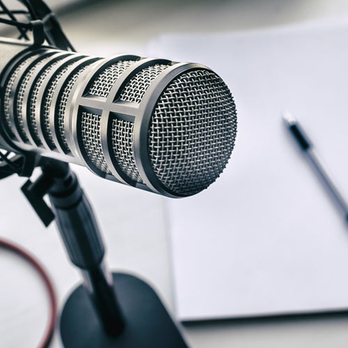 a microphone and a pen on a piece of paper