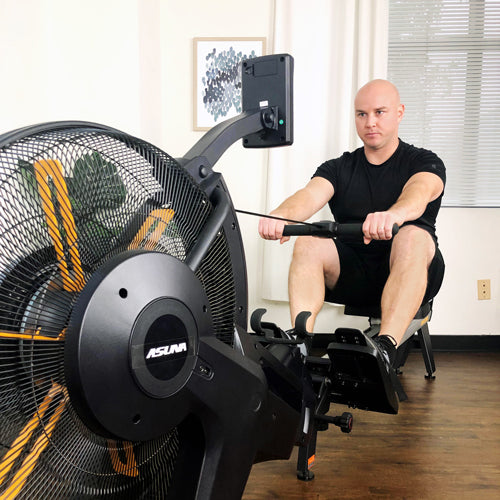 man performing exercise on rowing machine