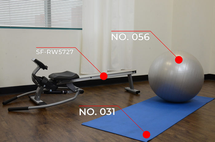 rowing machine, yoga mat, and silver gym ball in room 