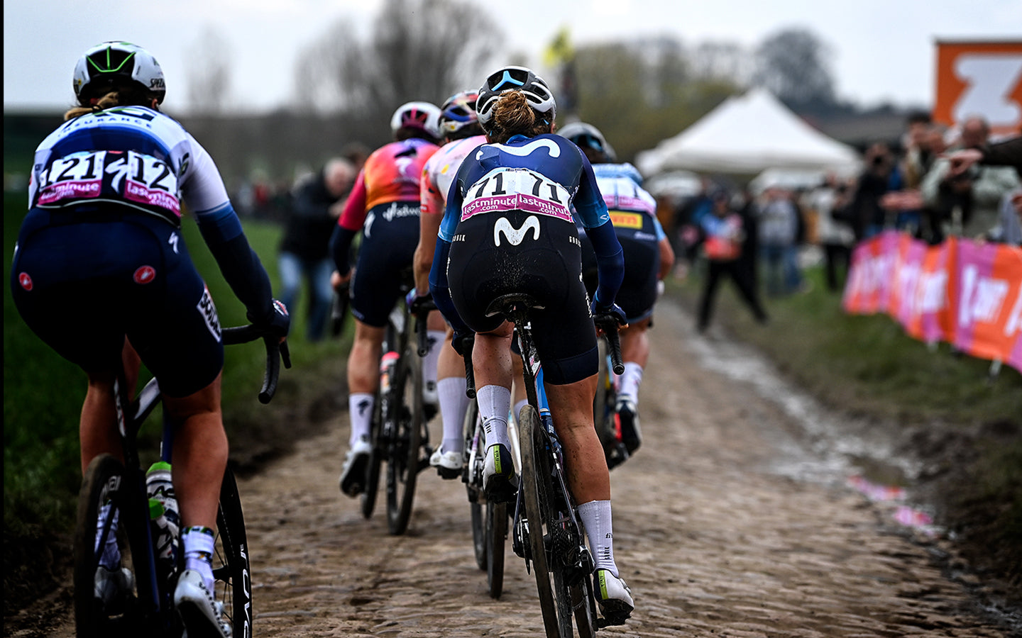 On his back, with the bib number 71, cyclist of the Movistar Team rider of the women's team crossing one of the characteristic pavé zones of the Paris-Roubaix race.