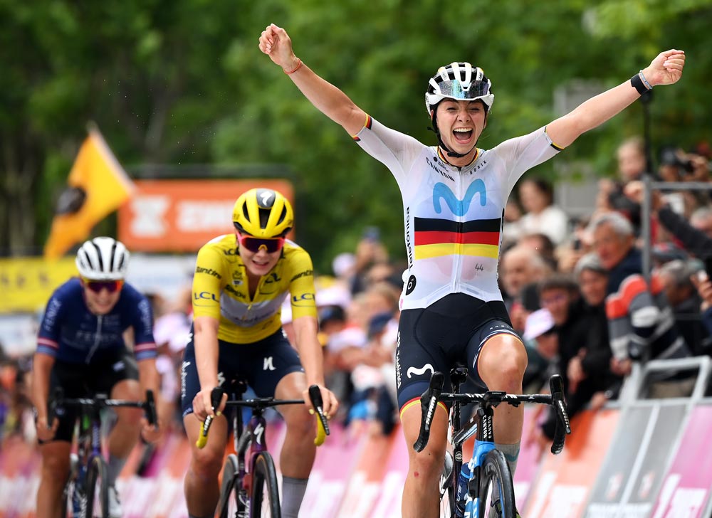 Liane Lippert fährt mit erhobenen Armen ins Ziel, nachdem sie in einem spannenden Sprint das Gelbe Trikot übernommen hat. 