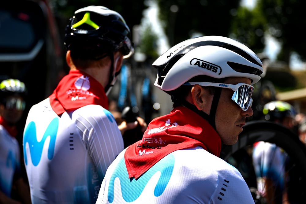 Two cyclists at the presentation of the team with the red scarf in honor of San Fermín around their necks. 