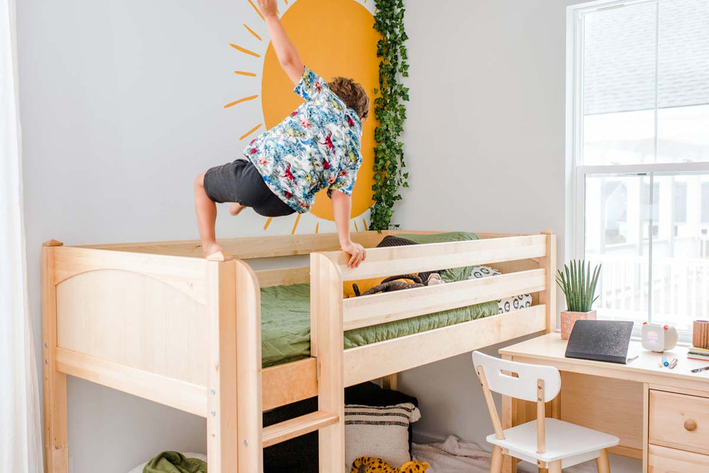 child playing on ladder of loft bed