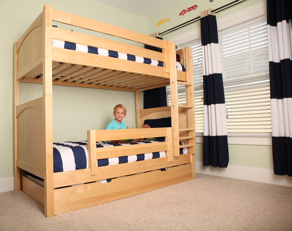 boy sitting on bottom bunk of tall bunk bed