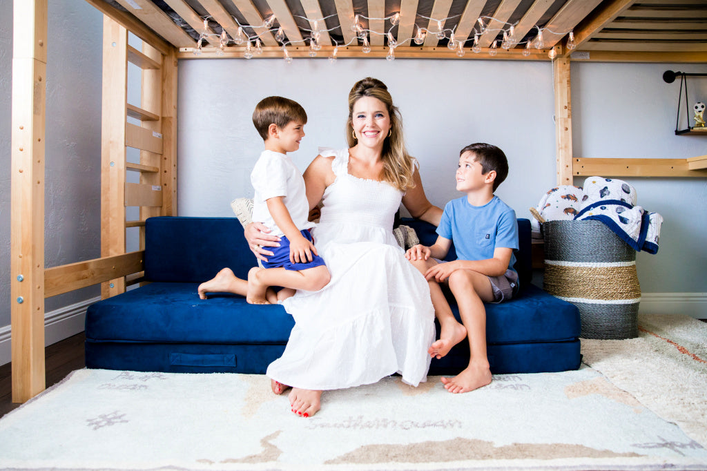 mom and kids under loft bed with lounge area