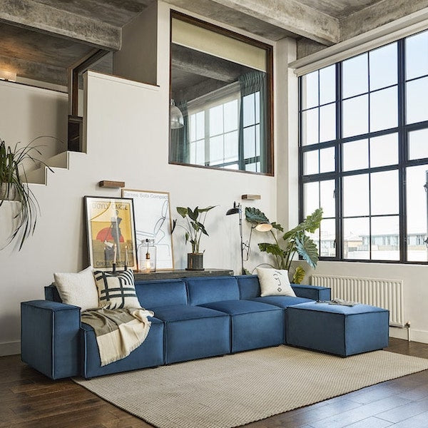 Blue L-shaped sofa in living room by window