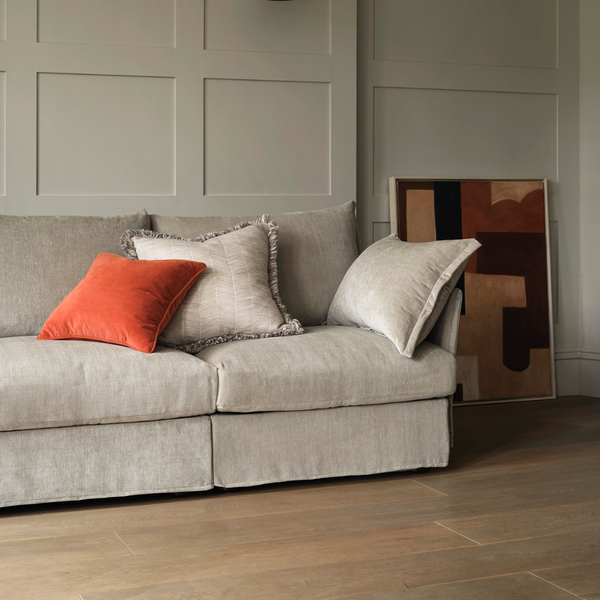 beige sofa neutral sofa linen fabric sofa corner sofa wall panels paneling DIY traditional style interior orange cushion red cushion oak floor