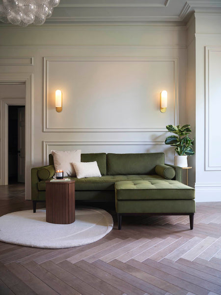 Green sofa with round white rug