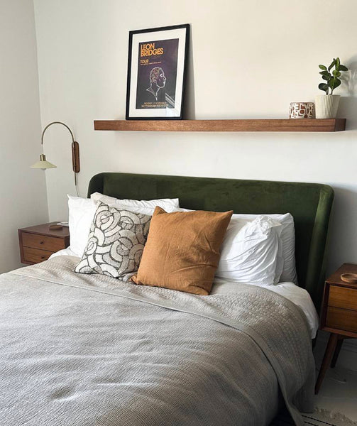 green velvet bed with shelf above headboard