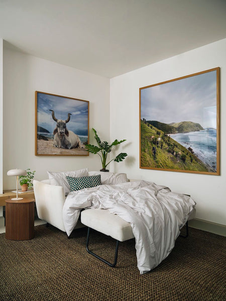 sofa bed with landscape art on wall