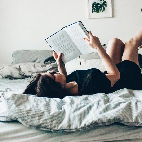 person reading a book in bed