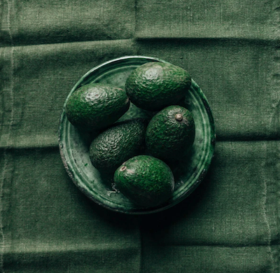 bowl of avocados on green linen tablecloth