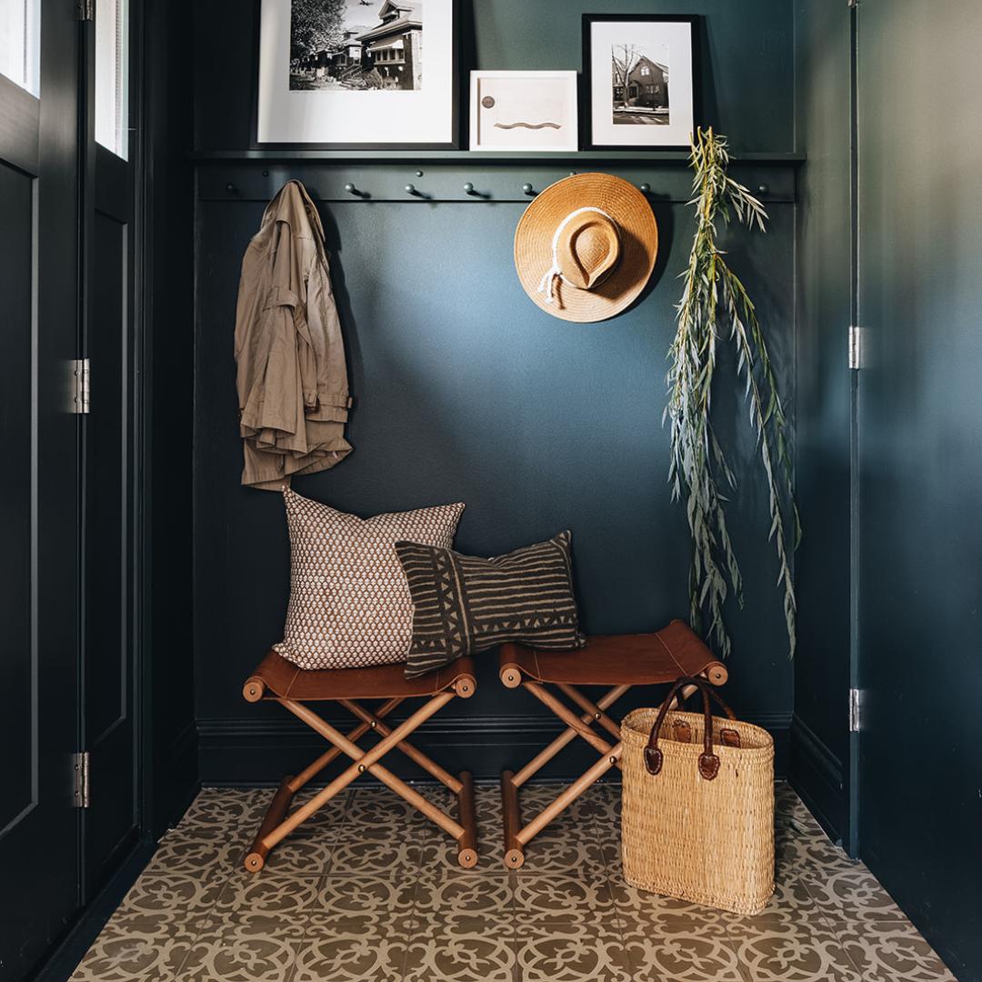 Blue entry way with boho home decor accents: leather benches and throw pillows