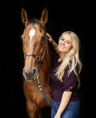 Jasmine Punter in promotional photo stood next to a brown horse, with a black background