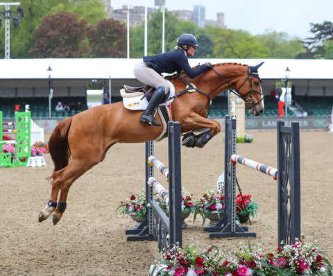 Side view of Jasmine Punter clearing a jump with her horse