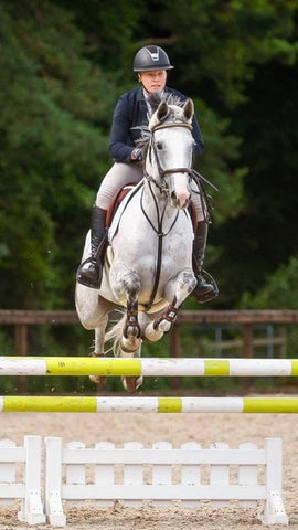 Front view of Natasha Swales mid-jump with her horse Mary
