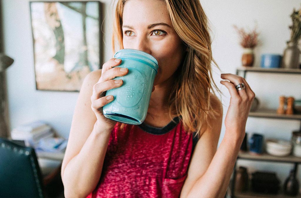 athletic woman drinking a low carb protein shake