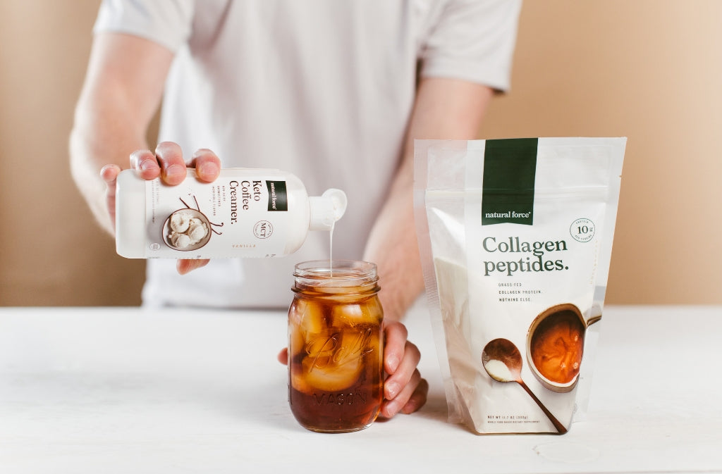 man pouring natural force keto coffee creamer into iced coffee next to bag of natural force collagen peptides