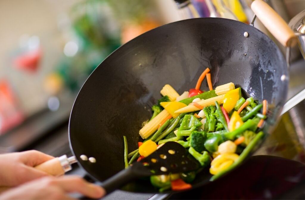 sautéing vegetables with mct oil in a wok