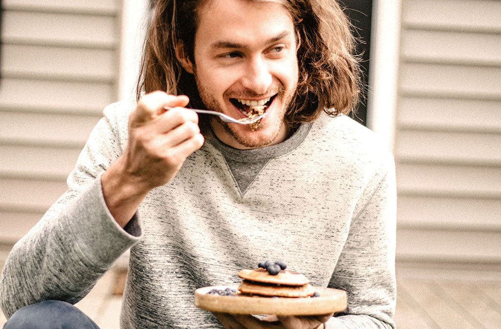 man smiling about to take a bit of paleo protein pancakes