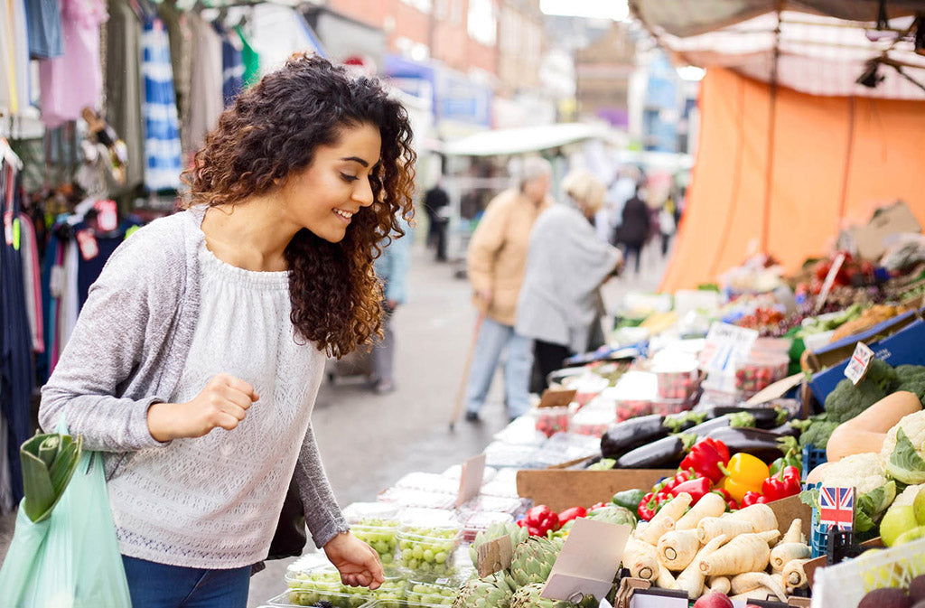 young woman looking at a farmers market stand