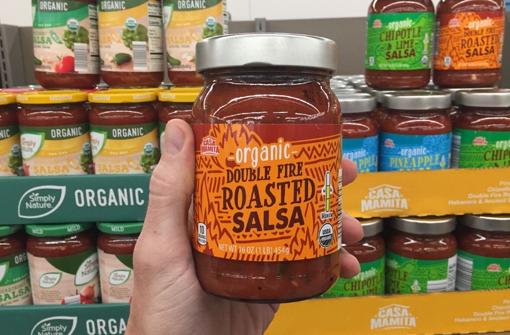 hand holding a jar of salsa