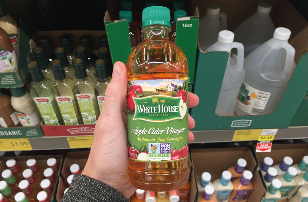 hand holding a bottle of apple cider vinegar